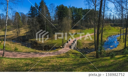 An old picturesque stone bridge in the landscaped spring park of Oranienbaum. An old picturesque stone bridge in the landscaped spring park of Oranienbaum. 138982752