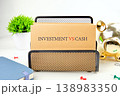 A prominent Investment VS Cash card sits in a black holder on a white desk 138983350
