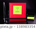 A neon green sticky note with CASH VS BONDS is attached to a red folder within a black mesh organizer. A pen stands beside it on a dark desk 138983354