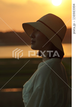 夕日に照らされる女性 夕日に照らされる女性 138983994