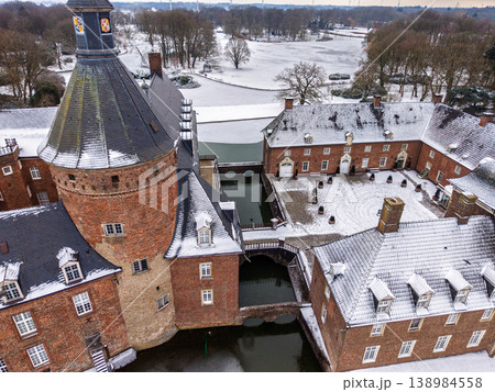 Aerial close-up of Anholt Castle, Wasserburg Anholt, in winter. The historic brick towers, snowy courtyard, and stone bridges over the frozen moat create a stunning medieval scene in Germany. Aerial close-up of Anholt Castle, Wasserburg Anholt, in winter. The historic brick towers, snowy courtyard, and stone bridges over the frozen moat create a stunning medieval scene in Germany. 138984558