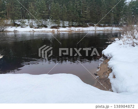 Winter river landscape with snowy banks and pine forest Winter river landscape with snowy banks and pine forest 138984872