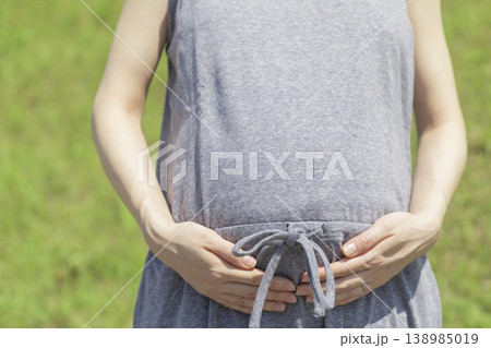 天気のよい日に妊婦さんがお腹をさわっているイメージ 天気のよい日に妊婦さんがお腹をさわっているイメージ 138985019