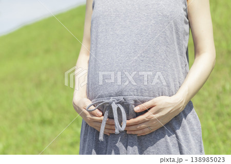 天気のよい日に妊婦さんがお腹をさわっているイメージ 天気のよい日に妊婦さんがお腹をさわっているイメージ 138985023