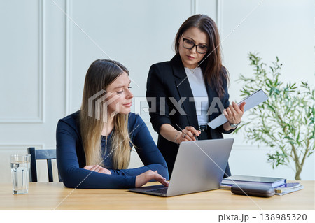 Confident female mentor teacher advising teaching young woman university student 138985320