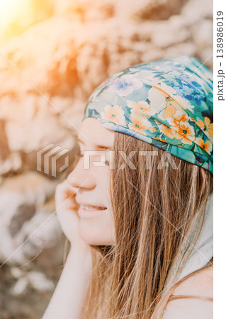 Woman headscarf summer Smiling young female with floral bandana outdoors enjoying golden hour sunlight Woman headscarf summer Smiling young female with floral bandana outdoors enjoying golden hour sunlight 138986019