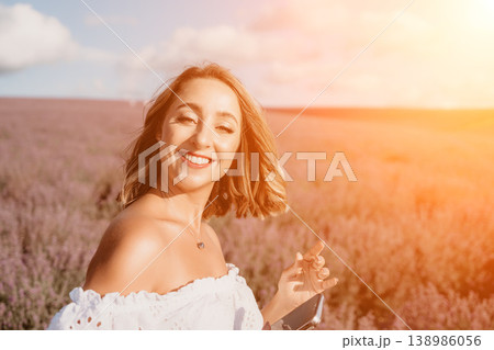 Woman lavender sunset smiling in purple blossom field at golden hour enjoying nature and sunlight Woman lavender sunset smiling in purple blossom field at golden hour enjoying nature and sunlight 138986056