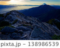 甲斐駒ヶ岳山頂から見る朝日差す甲府盆地と富士山・鳳凰山の眺め 138986539