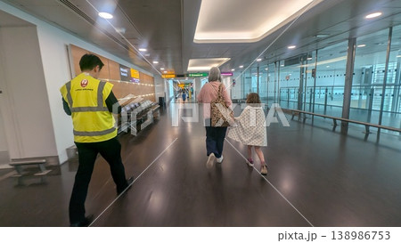 ヒースロー空港の乗り継ぎ通路を歩く旅行者 138986753