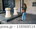 Young Woman Viewing Ancient Stone Columns in Museum Courtyard Cultural Exploration Scene 138988514
