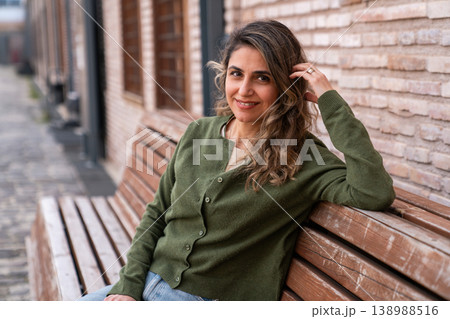 Smiling Woman Sitting on Wooden Bench Outdoors Casual Lifestyle Portrait Smiling Woman Sitting on Wooden Bench Outdoors Casual Lifestyle Portrait 138988516