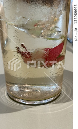 Glass with fizzy carbonated drink and fresh red chili pepper in transparent liquid background 138989668