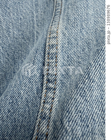 Close-up of blue denim fabric seam with detailed stitching texture, ideal for background use 138989676