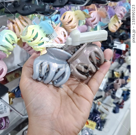 Yogyakarta, Indonesia - March 18th 2026 - Cinematic Calm Hand Holding Hair Clips in Store Aisle Yogyakarta, Indonesia - March 18th 2026 - Cinematic Calm Hand Holding Hair Clips in Store Aisle 138990123