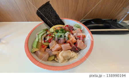 Poke bowl of tuna, salmon, sea bass, cucumber, scallion, and avocado Poke bowl of tuna, salmon, sea bass, cucumber, scallion, and avocado 138990194
