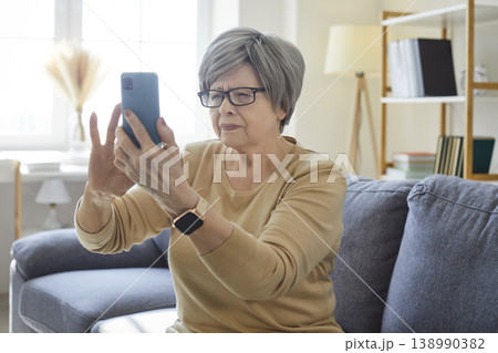 Senior woman with presbyopia and vision problem using smartphone at home Senior woman with presbyopia and vision problem using smartphone at home 138990382