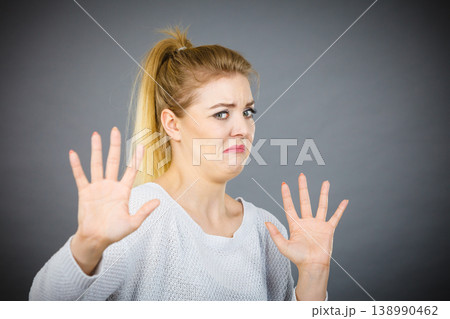 Scared woman gesturing stop gesture with hands 138990462