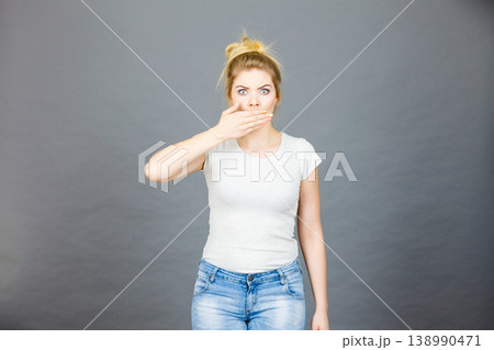 Woman covering her mouth with hand Woman covering her mouth with hand 138990471