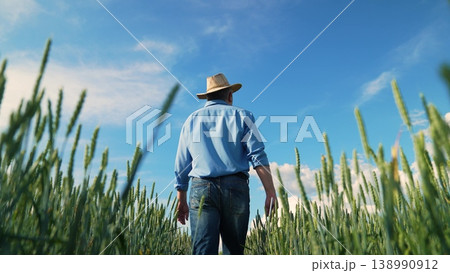 Wheat fields and blue skies, Portrait of a farmer at work, Man in jeans in agriculture, Nature and human in harmony, Wheat crop growing tall, Person strolling farm field, Hands-on farming business Wheat fields and blue skies, Portrait of a farmer at work, Man in jeans in agriculture, Nature and human in harmony, Wheat crop growing tall, Person strolling farm field, Hands-on farming business 138990912