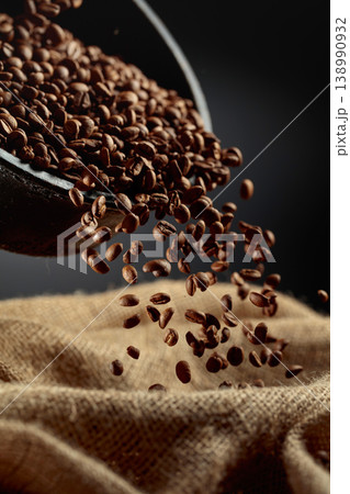 Freshly roasted coffee beans are poured into a bag. Freshly roasted coffee beans are poured into a bag. 138990932