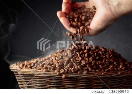 The freshly roasted coffee beans are poured into a basket. 138990949
