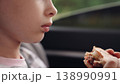 little girl child eating burger in car, happy person, Joyful kid traveler, eating while buckled up, burger time in car, roadside hunger, fresh air and food, travel companion, young one s delight 138990991