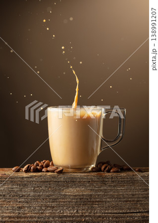 Glass cup of coffee drink, latte or mocha with splashes on a brown background. Glass cup of coffee drink, latte or mocha with splashes on a brown background. 138991207