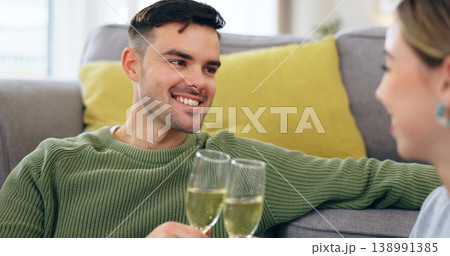Couple, happy man and champagne for cheers in living room for celebration, anniversary and event. Husband, face and smile with spouse for good news with drink, glass and home for sitting on floor 138991385