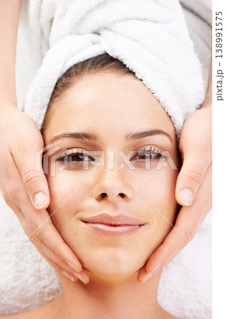 Portrait, spa massage and hands on face of woman from above at resort for stress relief or wellness. Top view, facial and lady client with masseuse at beauty salon for luxury, skincare or dermatology Portrait, spa massage and hands on face of woman from above at resort for stress relief or wellness. Top view, facial and lady client with masseuse at beauty salon for luxury, skincare or dermatology 138991575