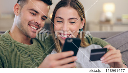 Couple, phone and credit card on couch in home for online shopping, sales or banking in living room. Man, woman and smartphone for easy payment, e commerce or happy for discount deal on lounge sofa 138991677
