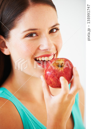 Health, diet and portrait of woman with apple eating for nutrition, wellness and snack in studio. Food, happy and face of person with fruit for vitamins, detox and lose weight on white background 138991747
