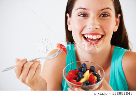 Diet, fruit salad and portrait of happy woman in studio eating for nutrition, wellness and snack. Food, health and face of person with berries for vitamins, detox and lose weight on white background 138991843