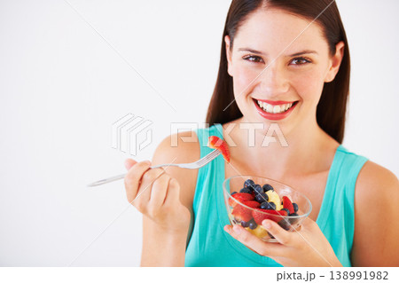 Food, fruit salad and portrait of woman with smile eating for nutrition, wellness and berry snack in studio. Health, happy and face of person for vitamins, diet and lose weight on white background 138991982