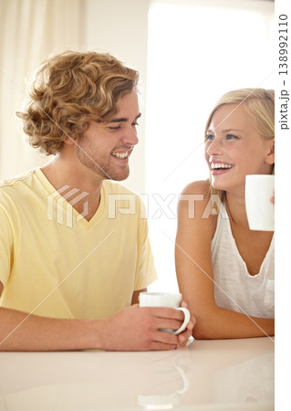 Love, coffee and smile with a couple in their home together, laughing in the morning for fun or romance. Face, happy or funny with a young man and woman drinking tea or bonding in their apartment 138992110