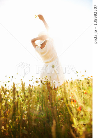 Freedom, back and woman at wheat field with flower in the countryside in summer, vacation or travel. Rear view, person in hat at farm or nature, garden or outdoor for stretching, lens flare or mockup Freedom, back and woman at wheat field with flower in the countryside in summer, vacation or travel. Rear view, person in hat at farm or nature, garden or outdoor for stretching, lens flare or mockup 138992307