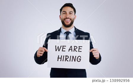 Happy businessman, portrait and hiring sign for opportunity, advertising or marketing against a gray studio background. Man smile with billboard or poster for recruiting, interview or career position Happy businessman, portrait and hiring sign for opportunity, advertising or marketing against a gray studio background. Man smile with billboard or poster for recruiting, interview or career position 138992956