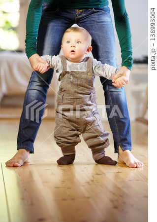 Mother, baby and helping with walking in home with support, trust and care for childhood development. Toddler, little boy and holding hand for motor skills, assistance and mobility in living room Mother, baby and helping with walking in home with support, trust and care for childhood development. Toddler, little boy and holding hand for motor skills, assistance and mobility in living room 138993004