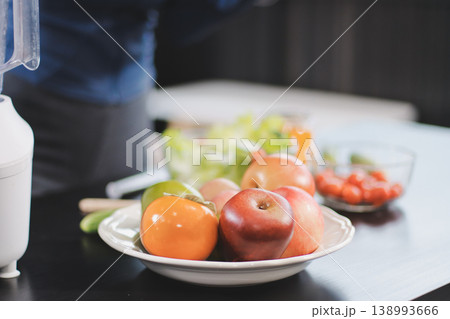 Young nutritionist showing bell peppers during an online video call consulting about healthy eating, sitting at home at a table with vegetables, laptop and measuring tape Young nutritionist showing bell peppers during an online video call consulting about healthy eating, sitting at home at a table with vegetables, laptop and measuring tape 138993666