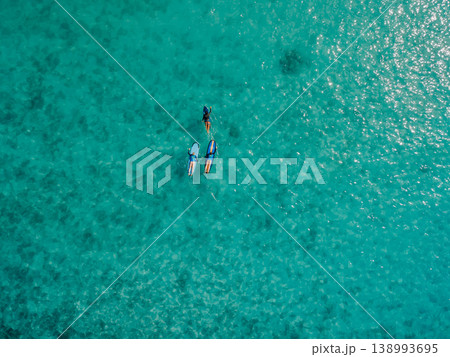 Aerial view of surfers on turquoise ocean in Bali, tropical summer vacation background Aerial view of surfers on turquoise ocean in Bali, tropical summer vacation background 138993695
