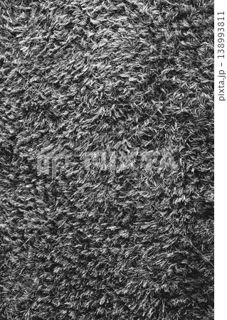 Grey fluffy carpet. Fur background, monochrome. Textured black and white surface. Vertical abstract background. Doormat backdrop. Grey fluffy carpet. Fur background, monochrome. Textured black and white surface. Vertical abstract background. Doormat backdrop. 138993811