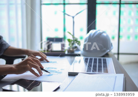 Professional Engineer Planning Sustainable Solar Energy Installation with Blueprints in office. Professional Engineer Planning Sustainable Solar Energy Installation with Blueprints in office. 138993959