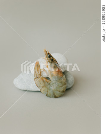 Shrimp and stones on a beige background. Shrimp and stones on a beige background. 138993985