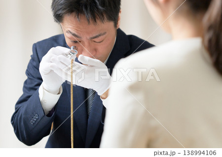 白手袋を着用した鑑定士がアクセサリーの状態を確認する買取査定の様子 138994106