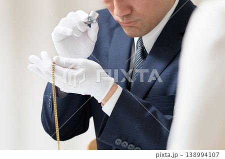 白手袋を着用した鑑定士がアクセサリーの状態を確認する買取査定の様子 白手袋を着用した鑑定士がアクセサリーの状態を確認する買取査定の様子 138994107