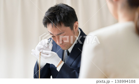 白手袋を着用した鑑定士がアクセサリーの状態を確認する買取査定の様子 138994108