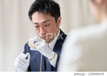 白手袋を着用した男性鑑定士がルーペを使用して鑑定している様子 138994245