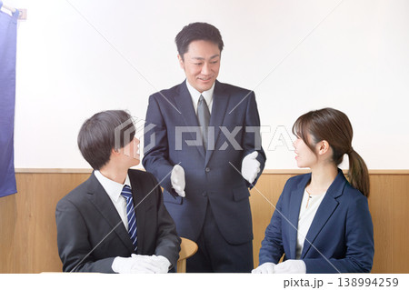 白手袋を着用したスタッフ同士が店舗内で打ち合わせを行う様子 138994259