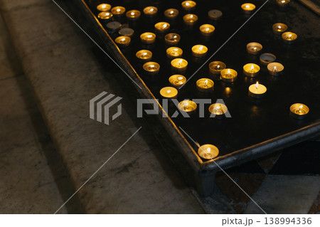 Burning candles in an old church. Burning candles in an old church. 138994336