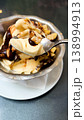 Sweet dessert - ice cream covered with chocolate, nuts and cream. 138994913