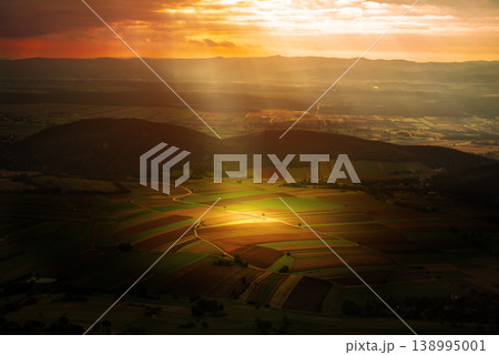 Sunlit Farmland Landscape in Austria, beautiful view with the sun ray Sunlit Farmland Landscape in Austria, beautiful view with the sun ray 138995001